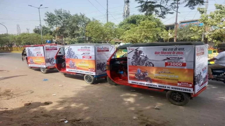 A branded auto rickshaw in Meerut moving through a busy market area, showcasing effective transit advertising for local businesses.