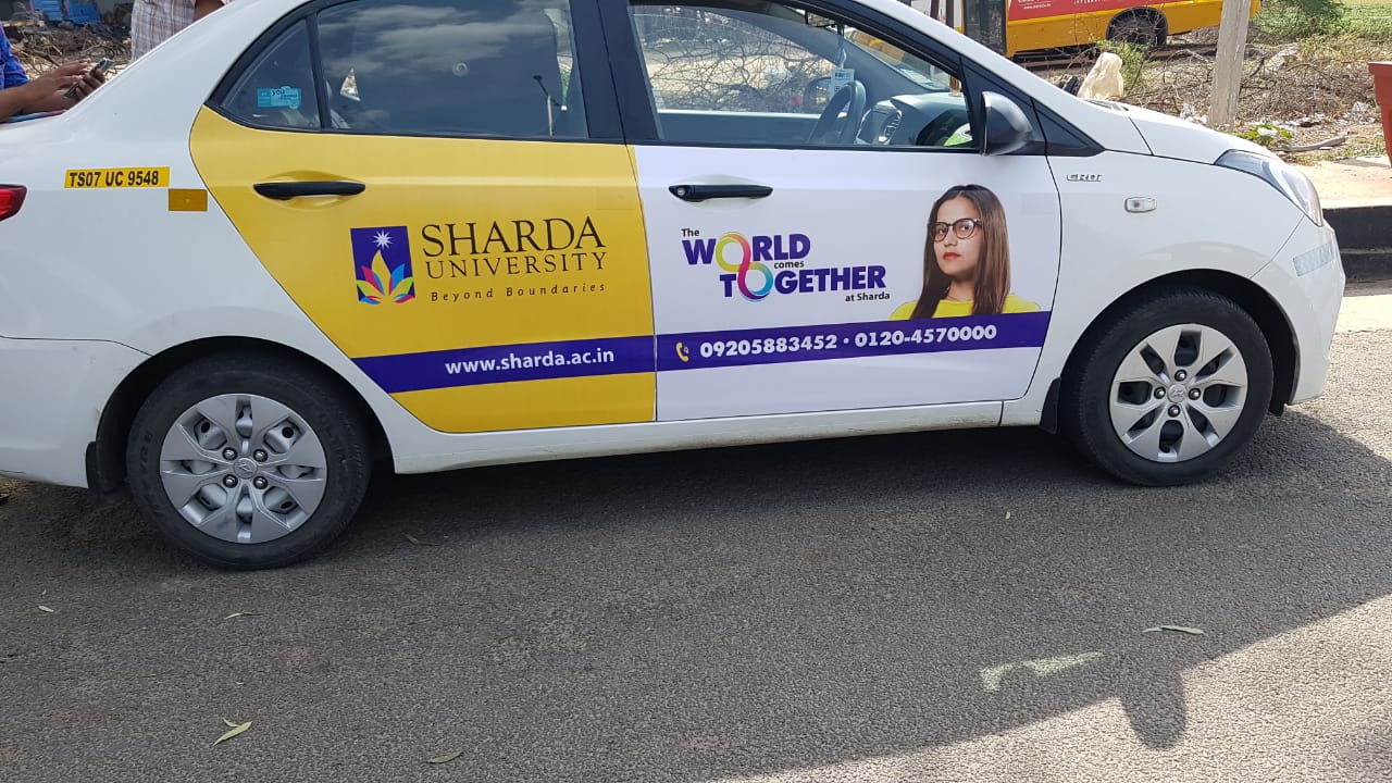 Sharda University’s car wrap ad promotes global learning and diversity through creative OOH transit advertising.