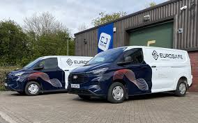 Taxi with LED top display showing a moving brand ad driving through heavy city traffic at night.